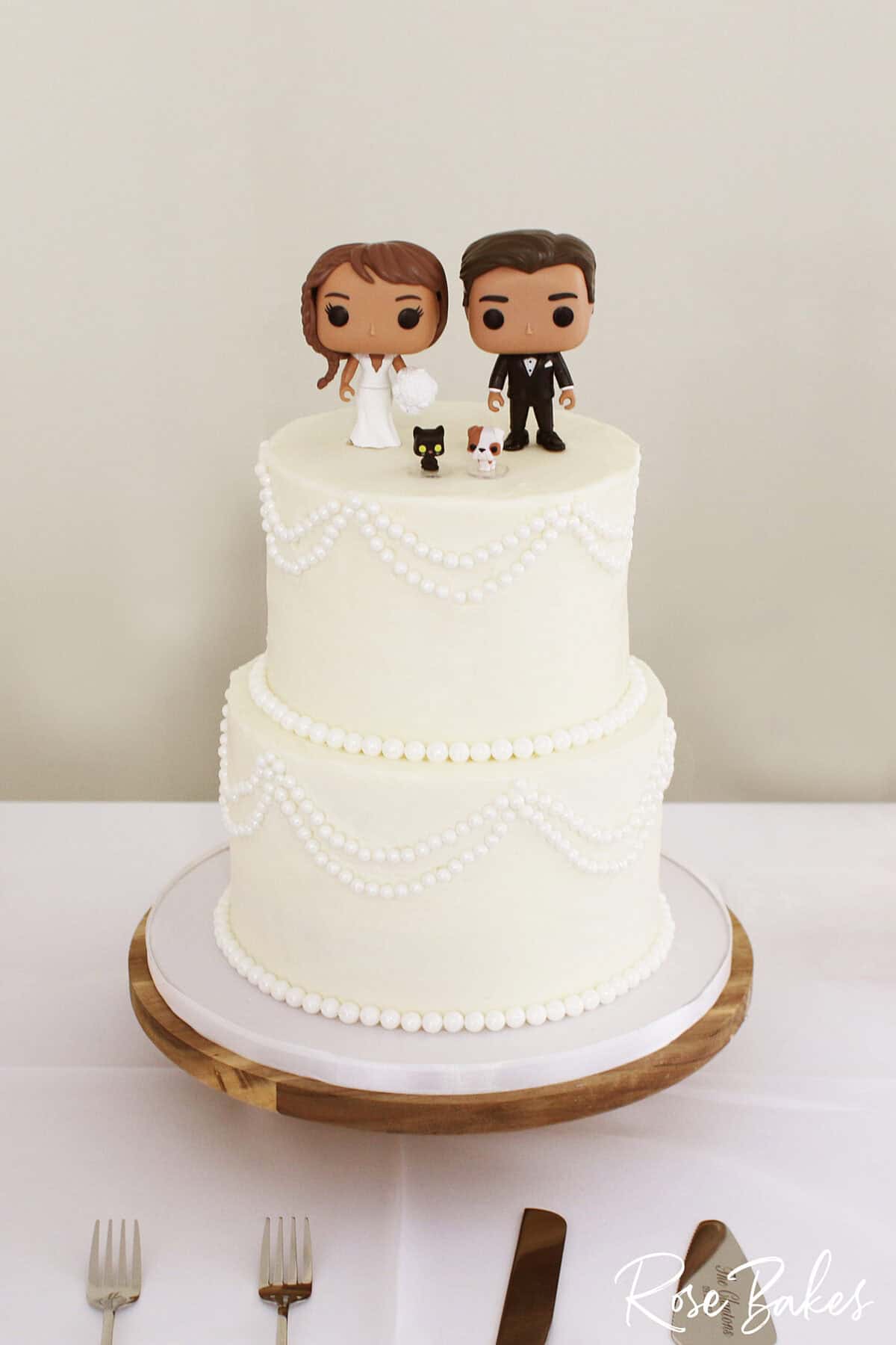 pearls wedding cake with bobble head bride and groom and pets