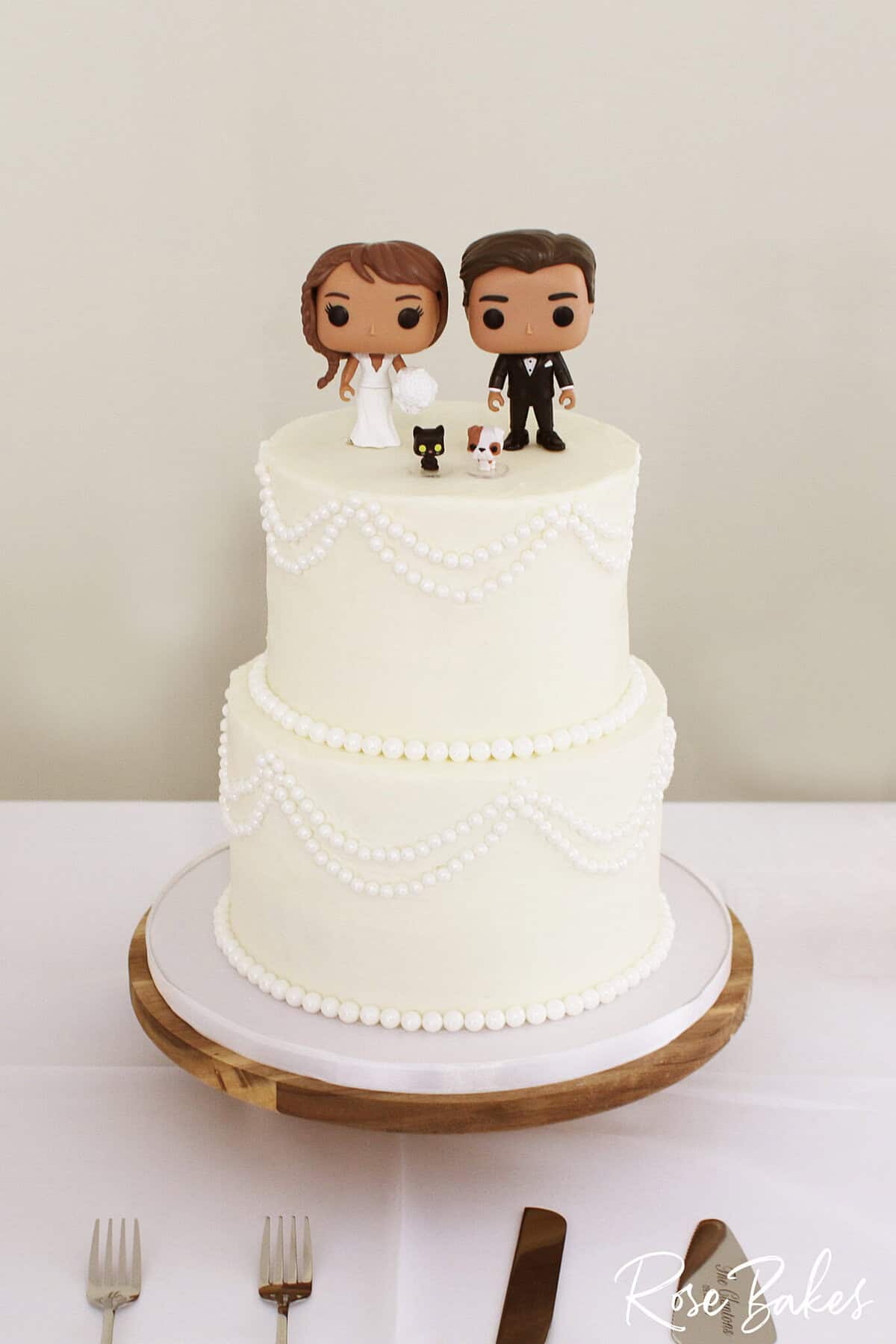 pearls wedding cake with bobble head bride and groom and pets