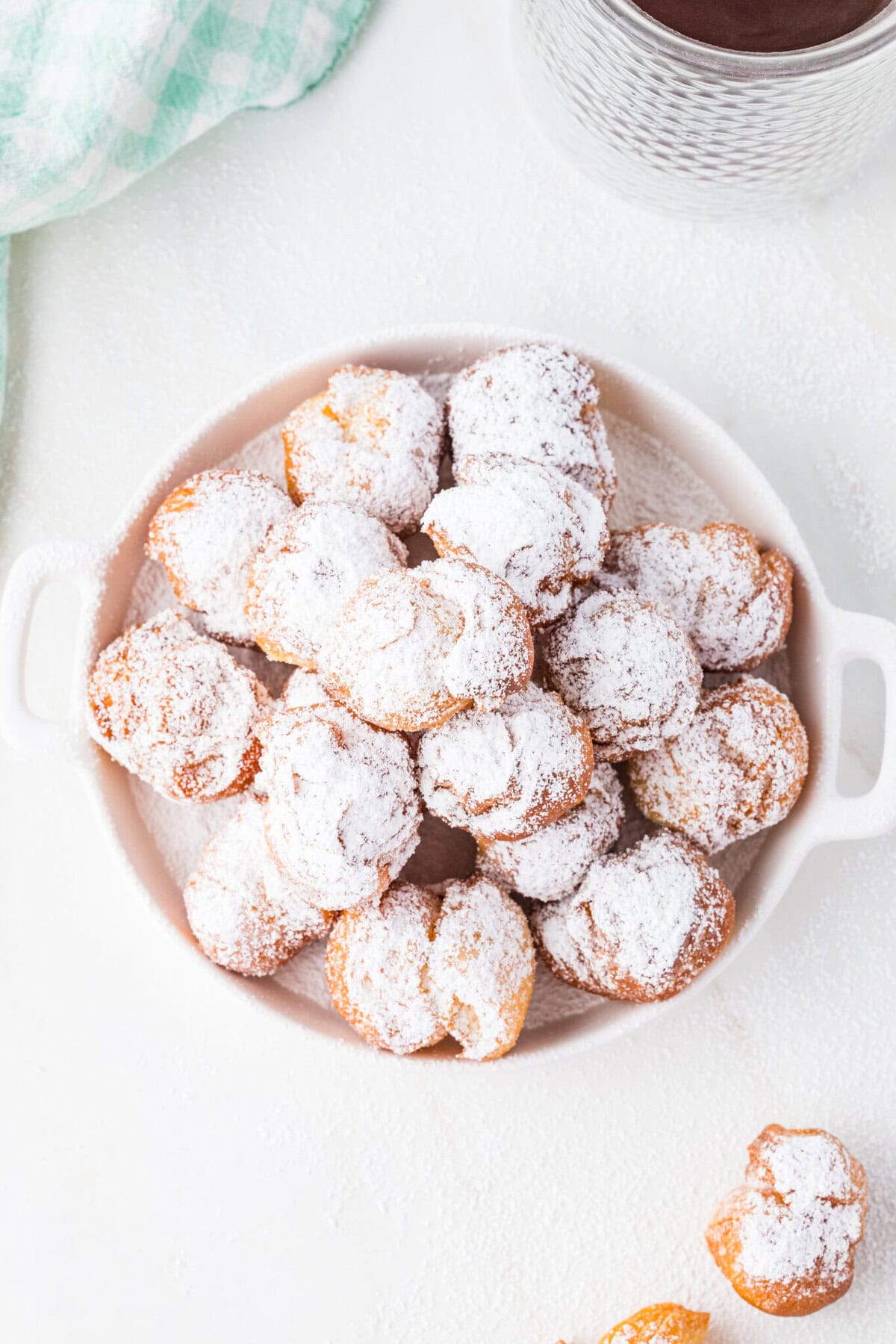 biscuit donut holes in a bowl with powdered sugar