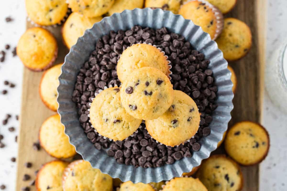 mini chocolate chip muffins stacked on a bowl of mini chocolate chips