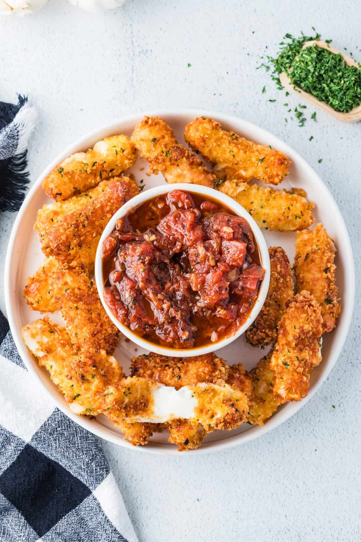 mozzarella cheesesticks on a platter with marinara sauce
