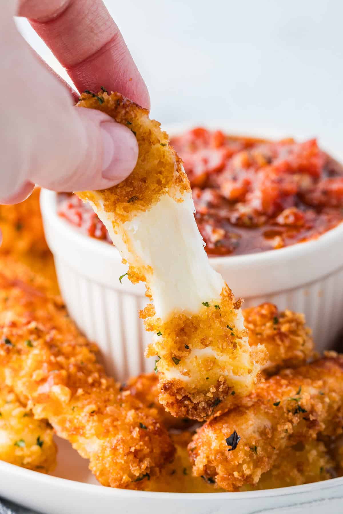 homemade mozzarella cheesesticks next to homemade marinara