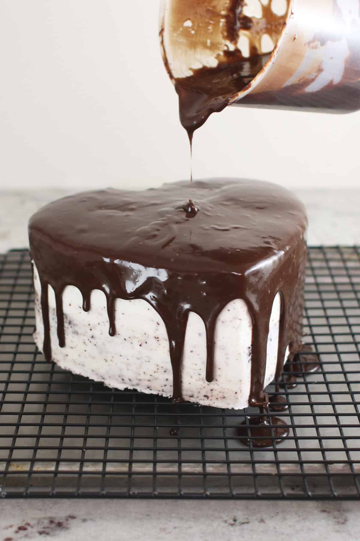 pouring ganache over cake