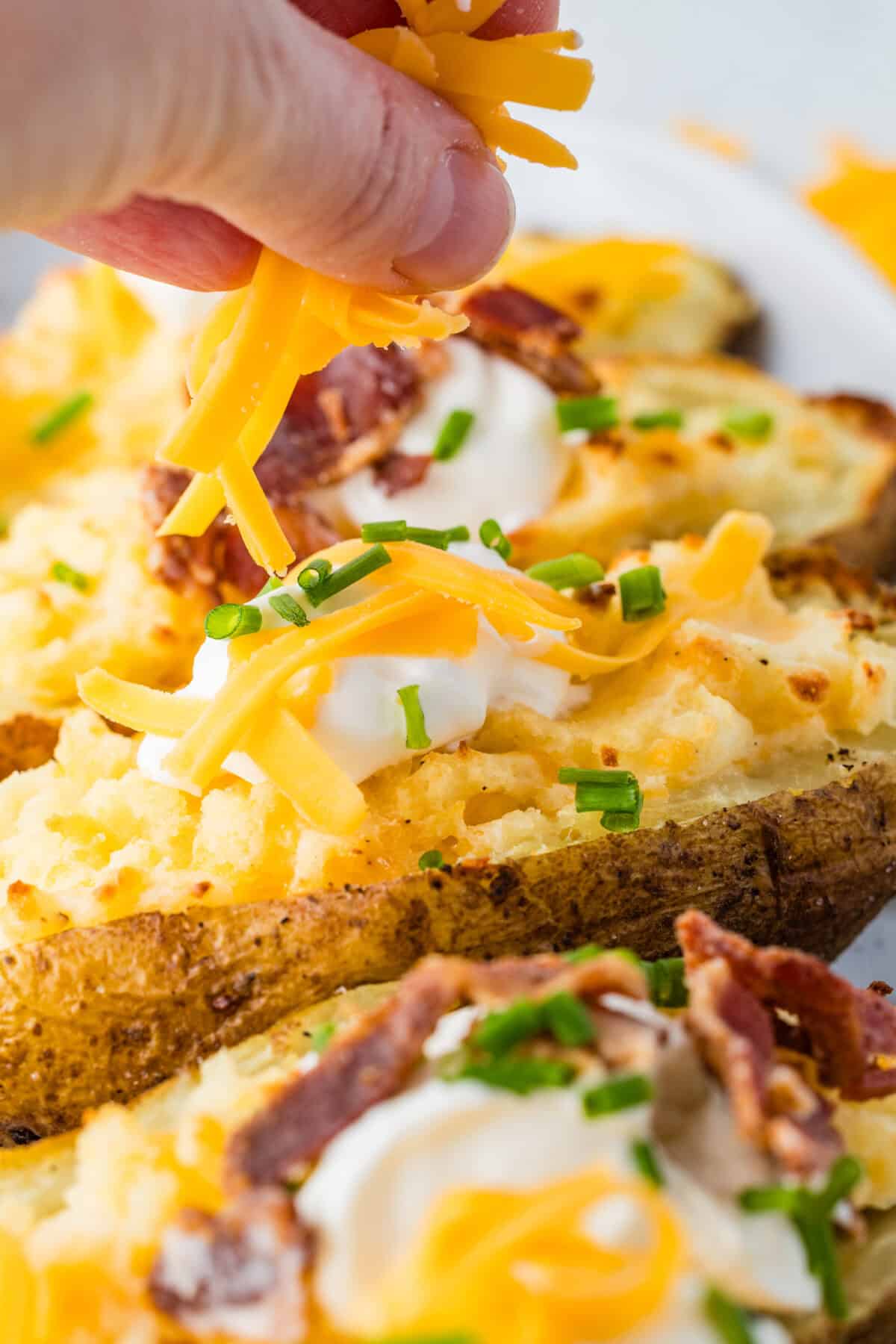twice baked potato with sour cream, cheese and bacon pieces