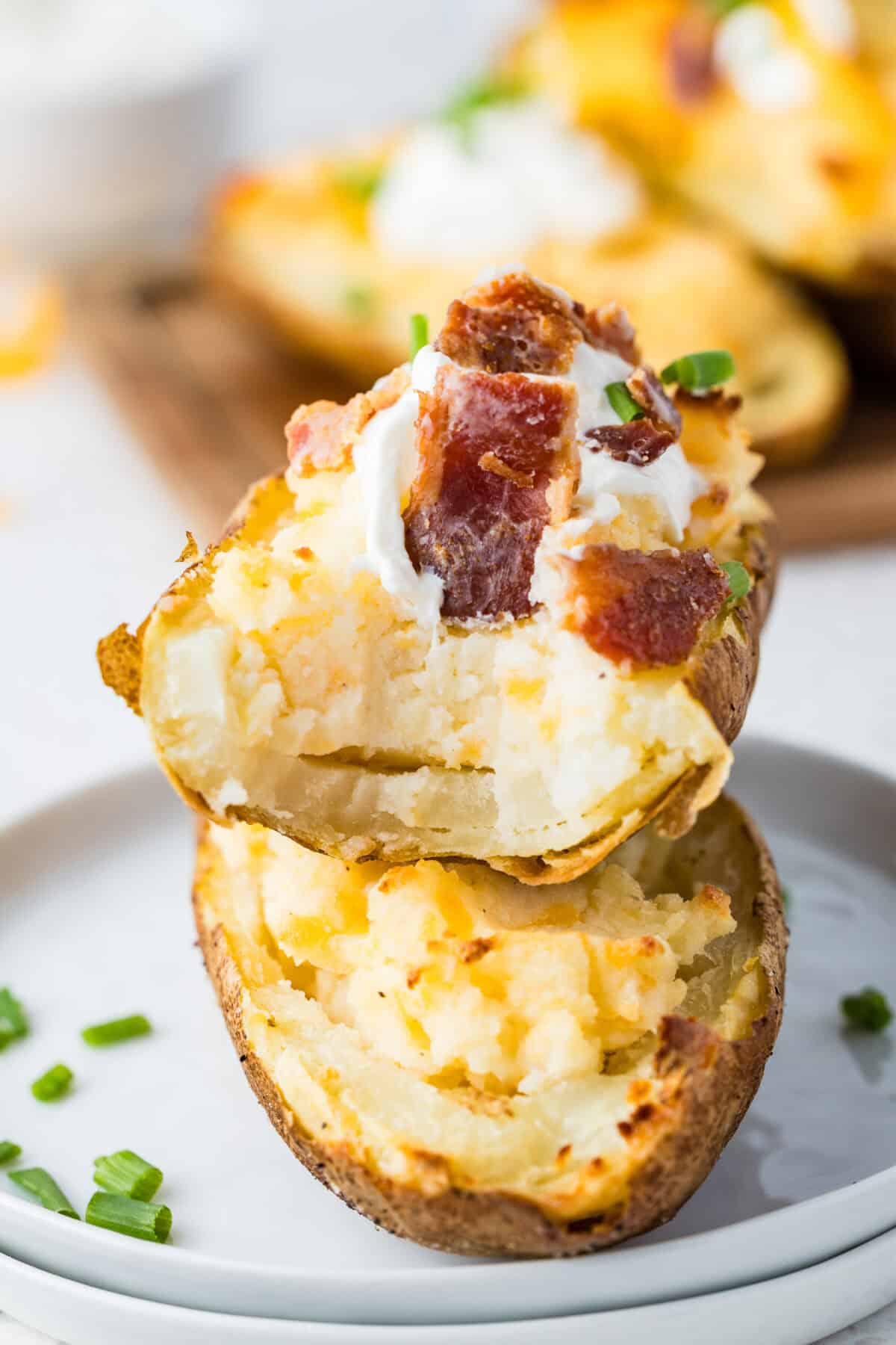 twice baked potato with sour cream, cheese and bacon pieces with a bite missing