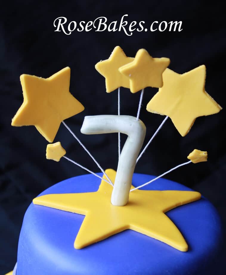 Gum Paste Number Stars Star Wars Cake Stars on wires coming out of the top of the cake with a 7 topper.