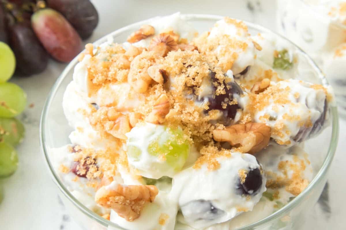 grape salad in a clear bowl with grapes on the side