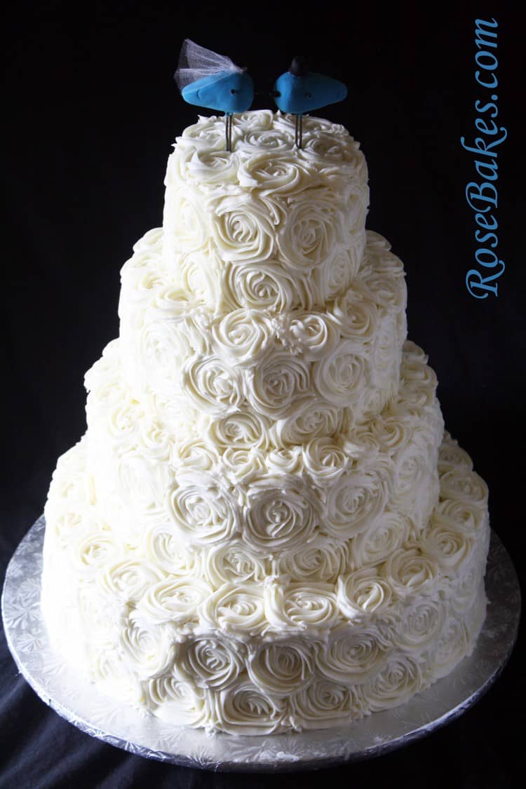 buttercream roses wedding cake with blue lovebirds topper