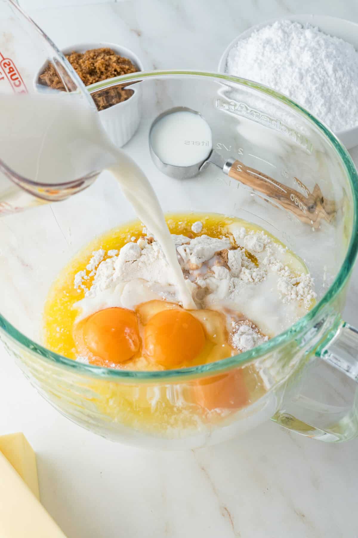 adding milk to cake batter for caramel cake