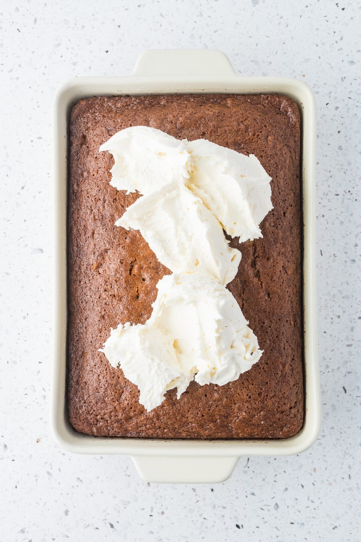 cream cheese frosting plopped on baked carrot cake