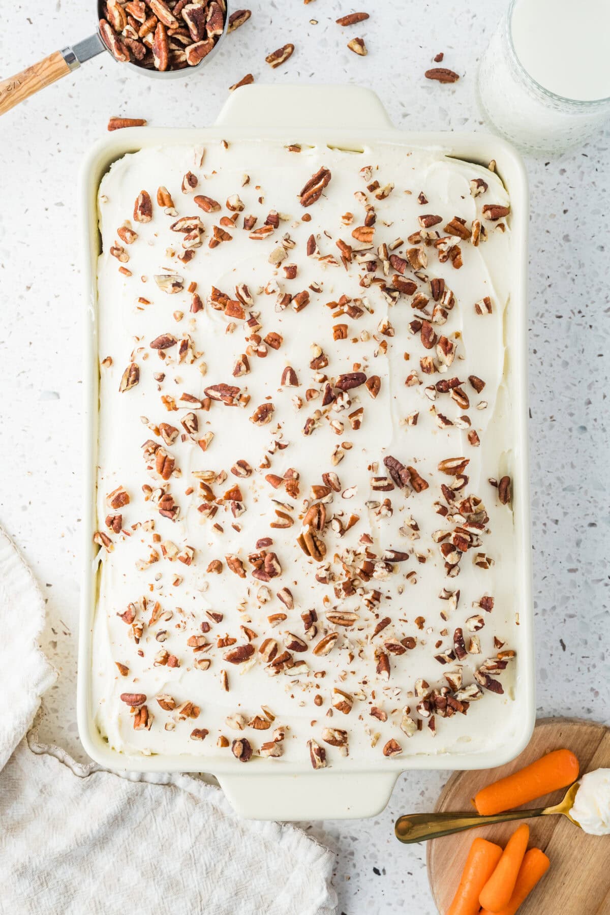 carrot cake with cream cheese frosting and pecans on top