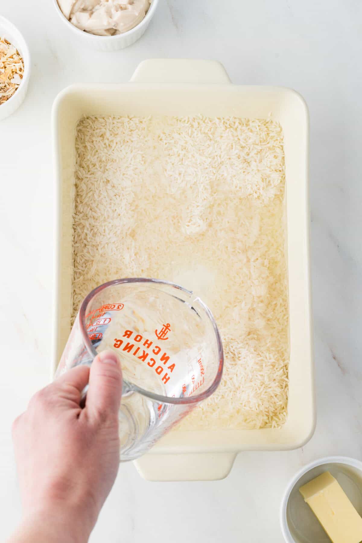 water pouring over rice in a baking dish