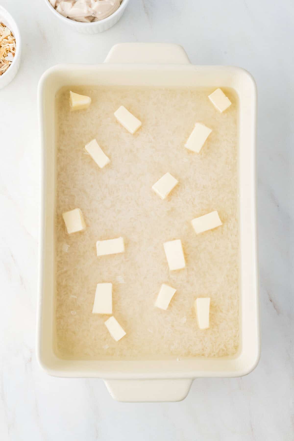 cubed butter in the rice and water in the baking dish