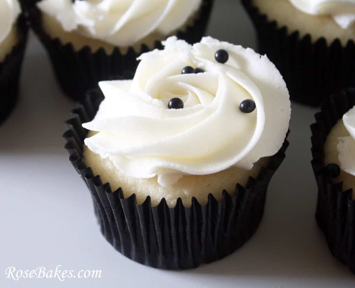 Cupcake with white frosting and black pearls on top
