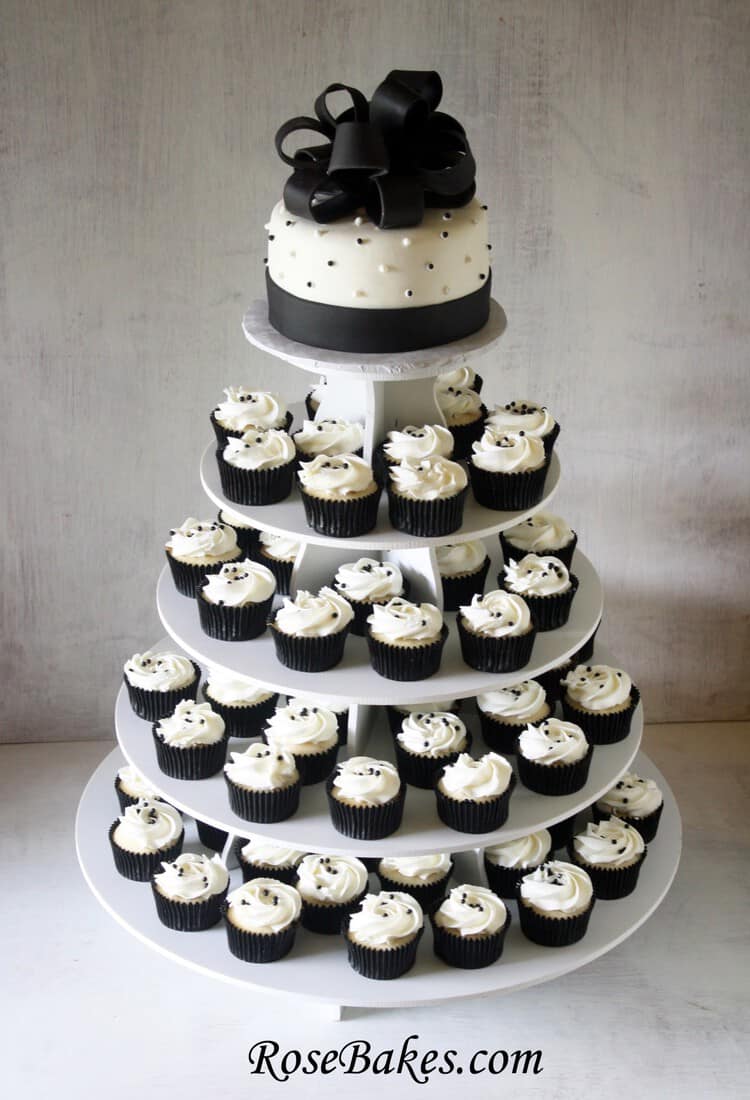 Black and white cupcake tower with 4 tiers of cupcakes and the top tier is cake