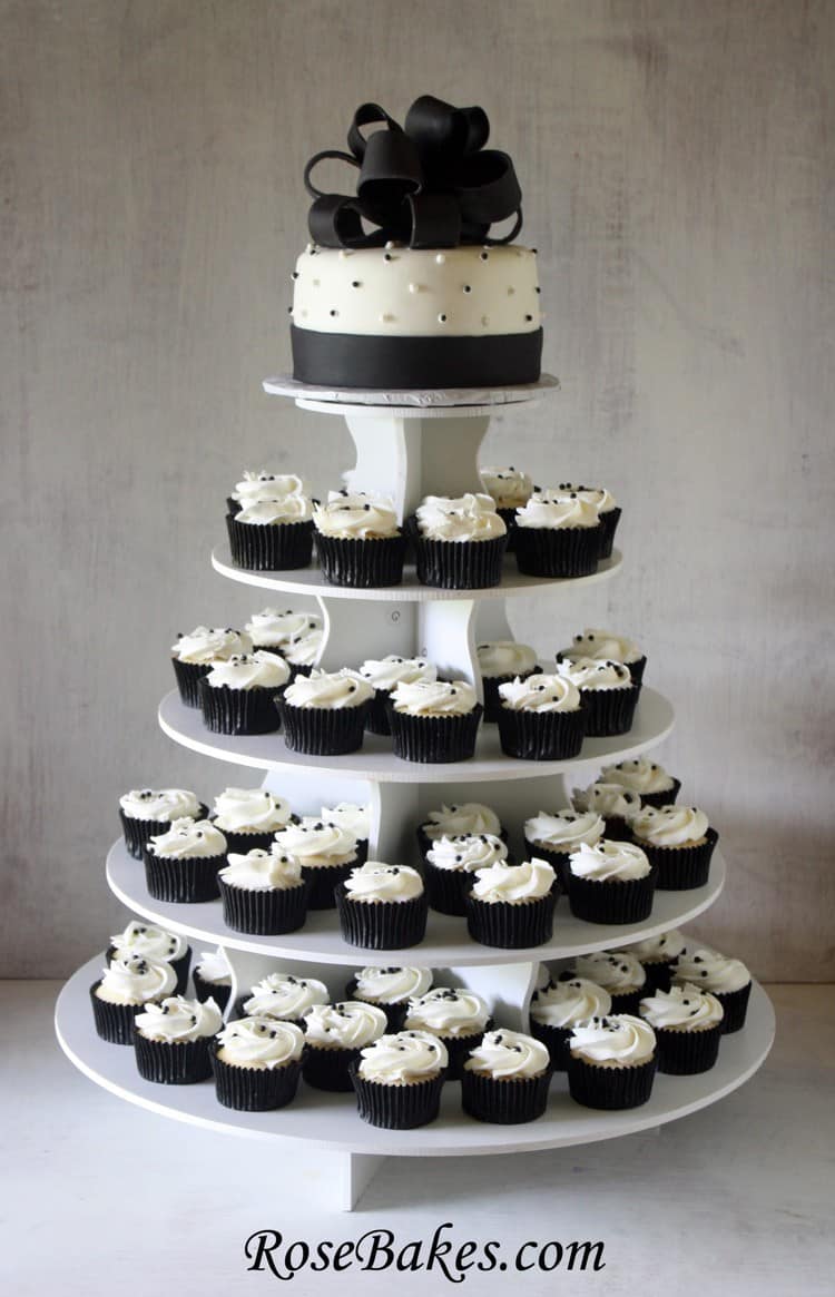 Black and white cupcake tower with 4 tiers of cupcakes and the top tier is cake
