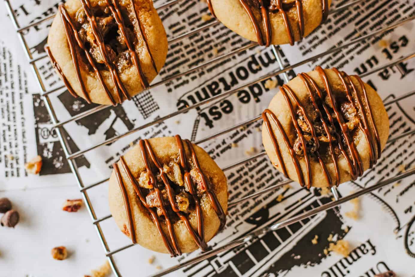 Chocolate Pecan Pie Cookies on a wire rack over newsprint