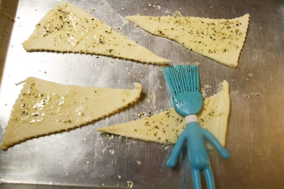 crescent rolls spread out then brushed with garlic butter