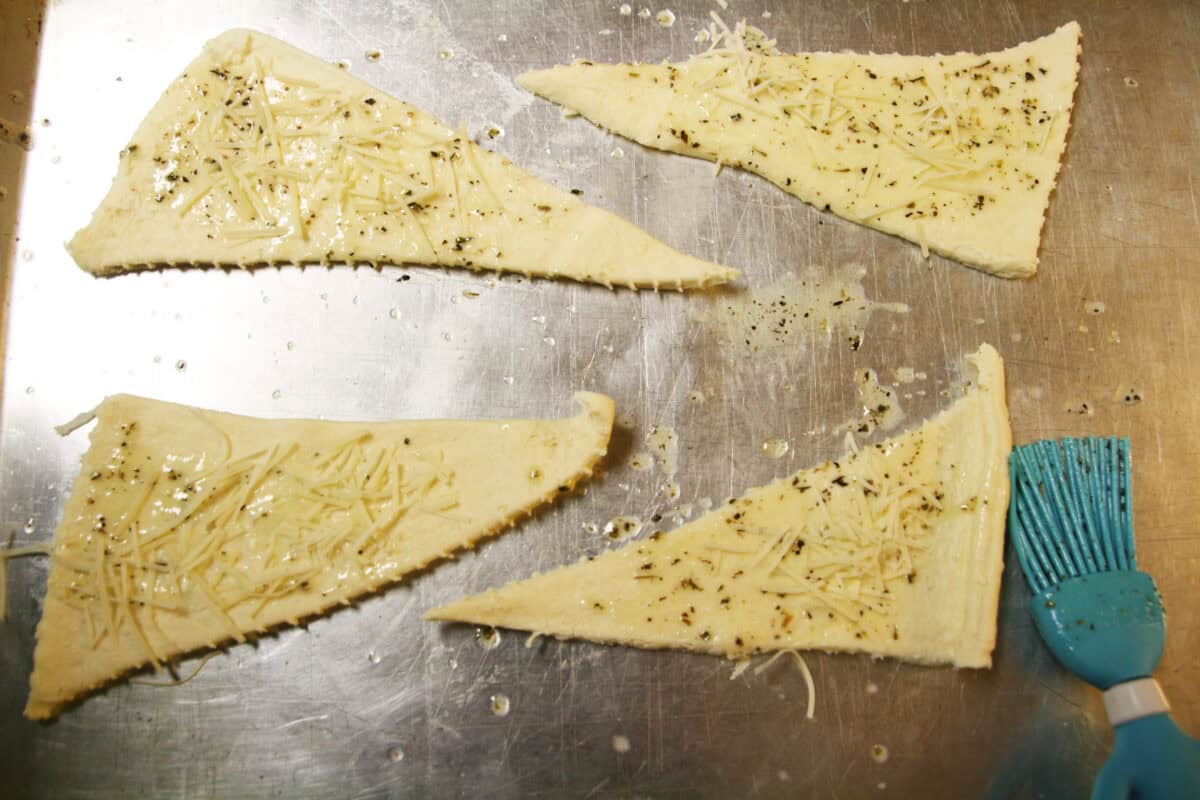 parmesan sprinkled onto buttered crescent rolls