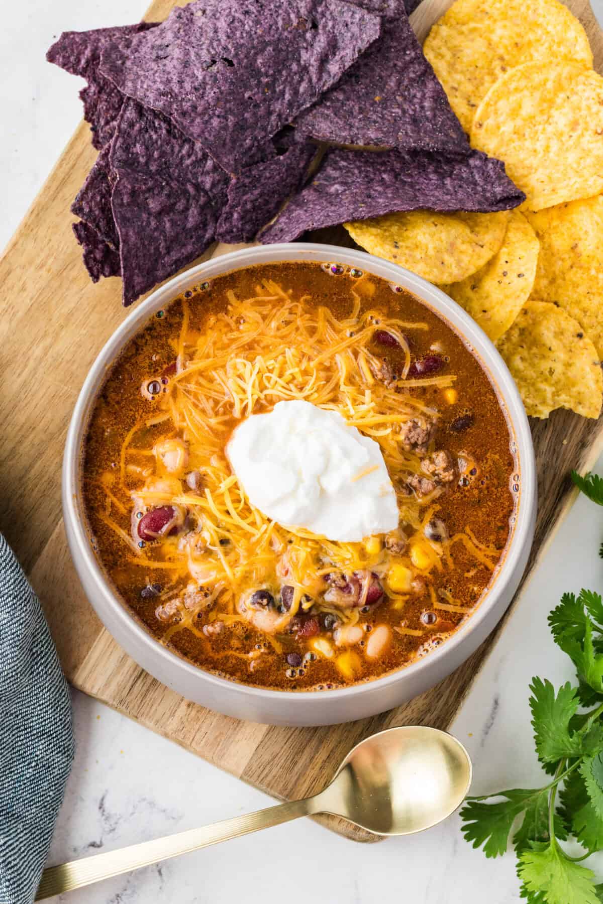 sour cream and cheese in bowl of taco soup surrounded by tortilla chips