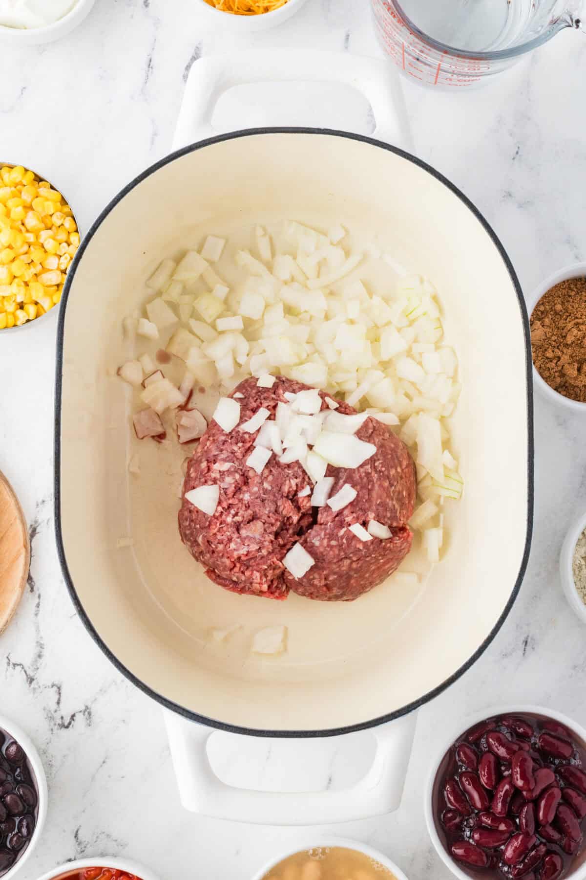 raw ground beef and onion in a dutch oven