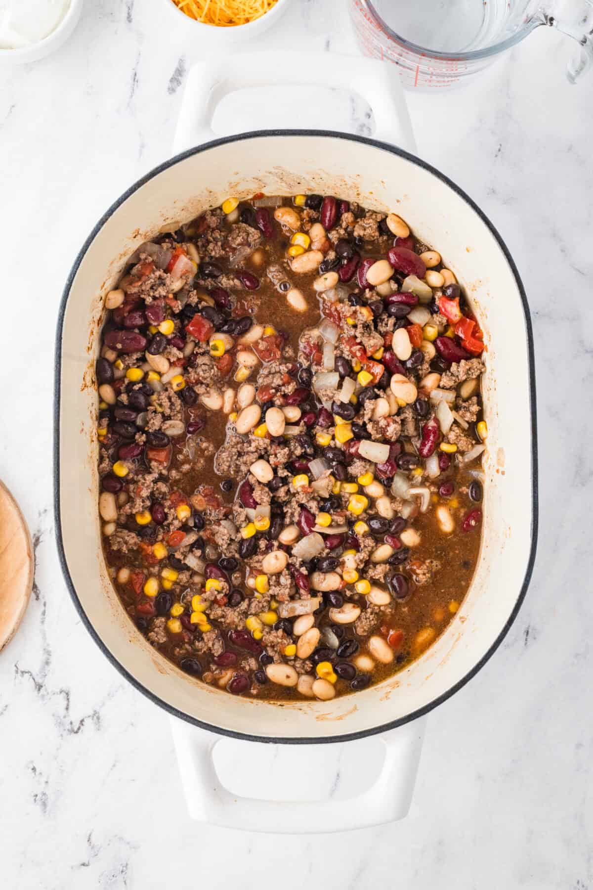 all ingredients for taco soup mixed with cooked ground beef and onions