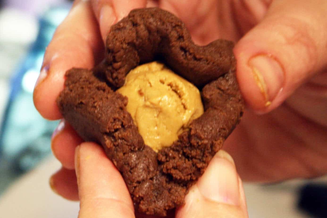 wrappeing cookie butter filling in flattened chocolate cookie dough