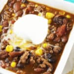 taco soup with sour cream and shredded cheese on top.