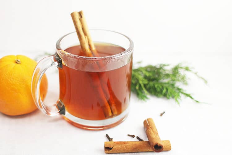 Hot Spiced Apple Cider with no Added Sugar in Clear Coffee Mug with Orange and Cinnamon Sticks
