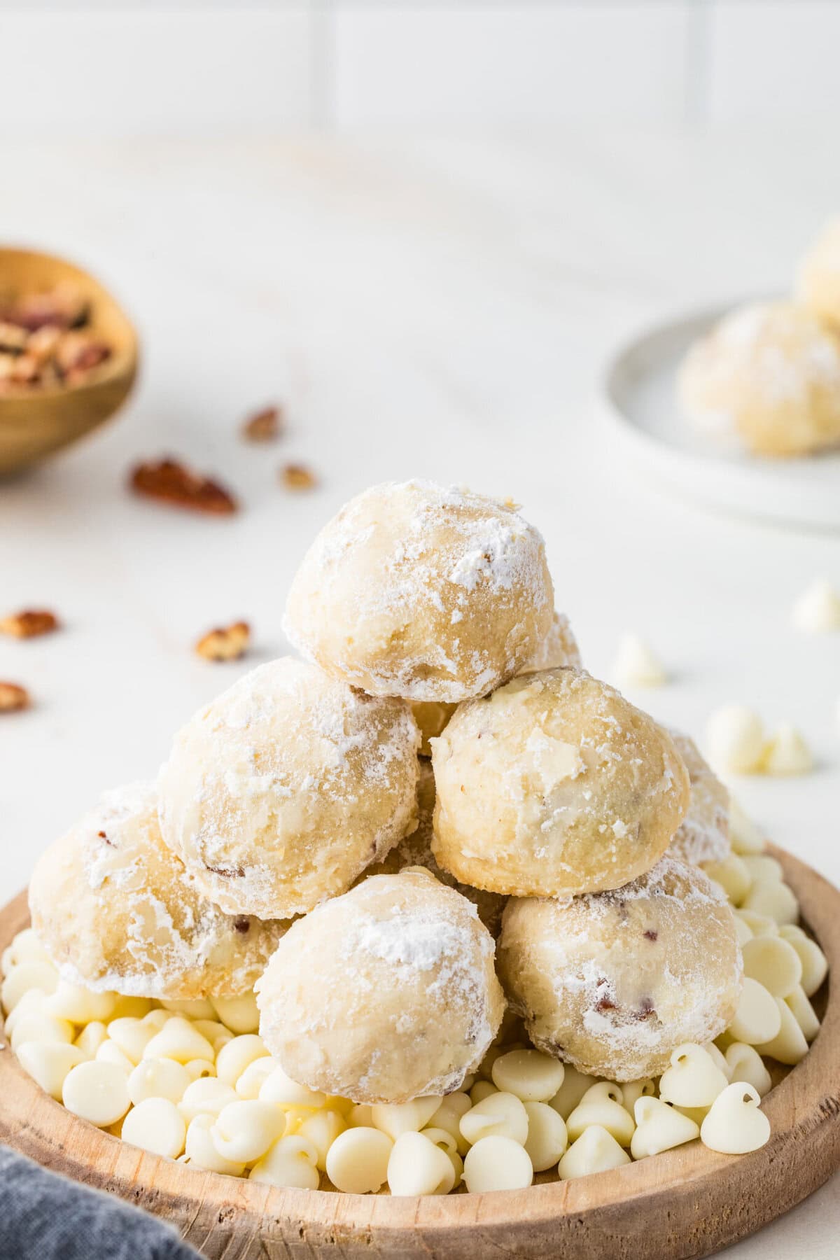 stack of Mexican Wedding Cookies on top of white chocolate chips