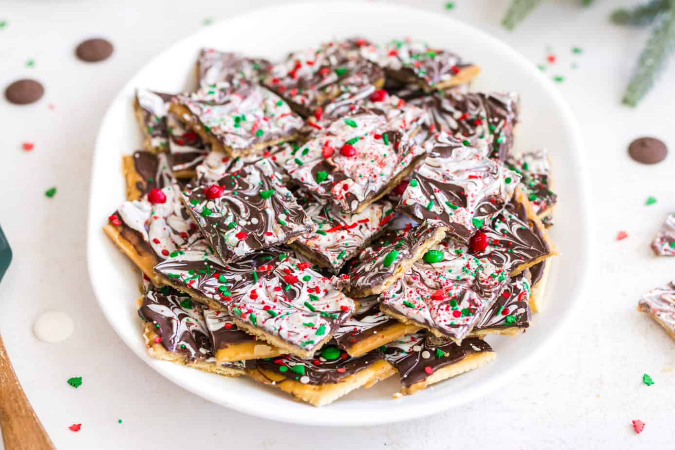 broken up pieces of saltine toffee cracker candy on a white plate