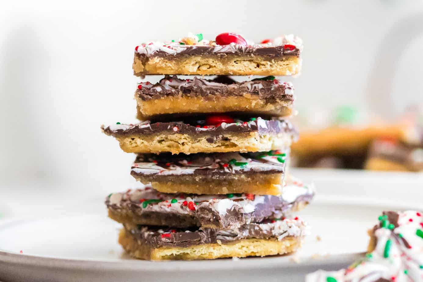 saltine cracker toffee stacked up on a white plate