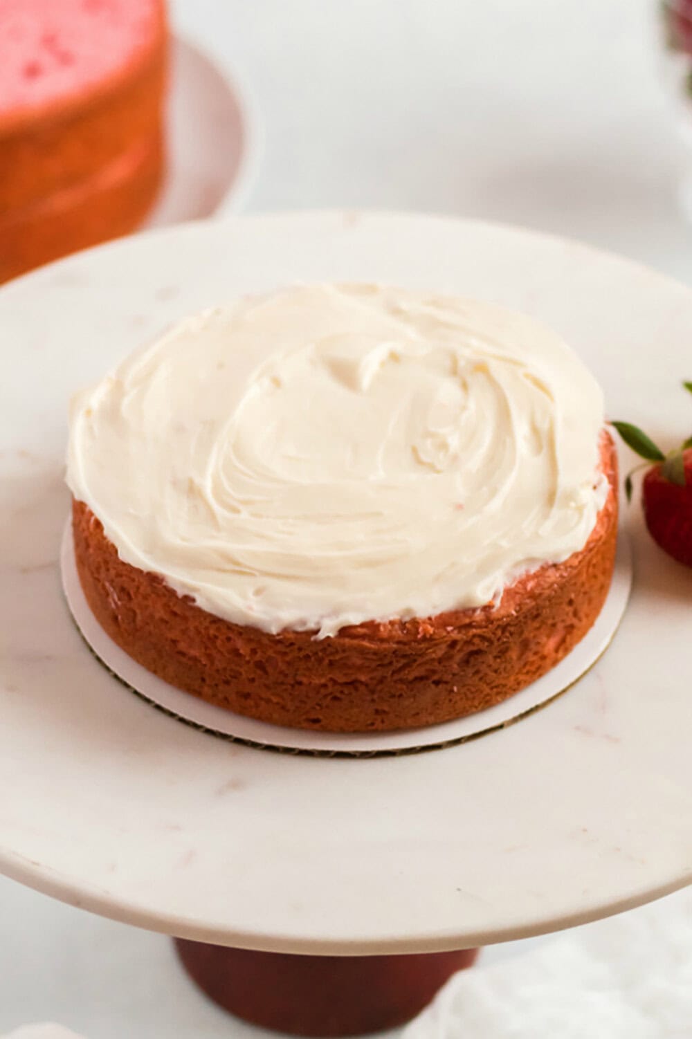 layer of strawberry cake with cream cheese frosting