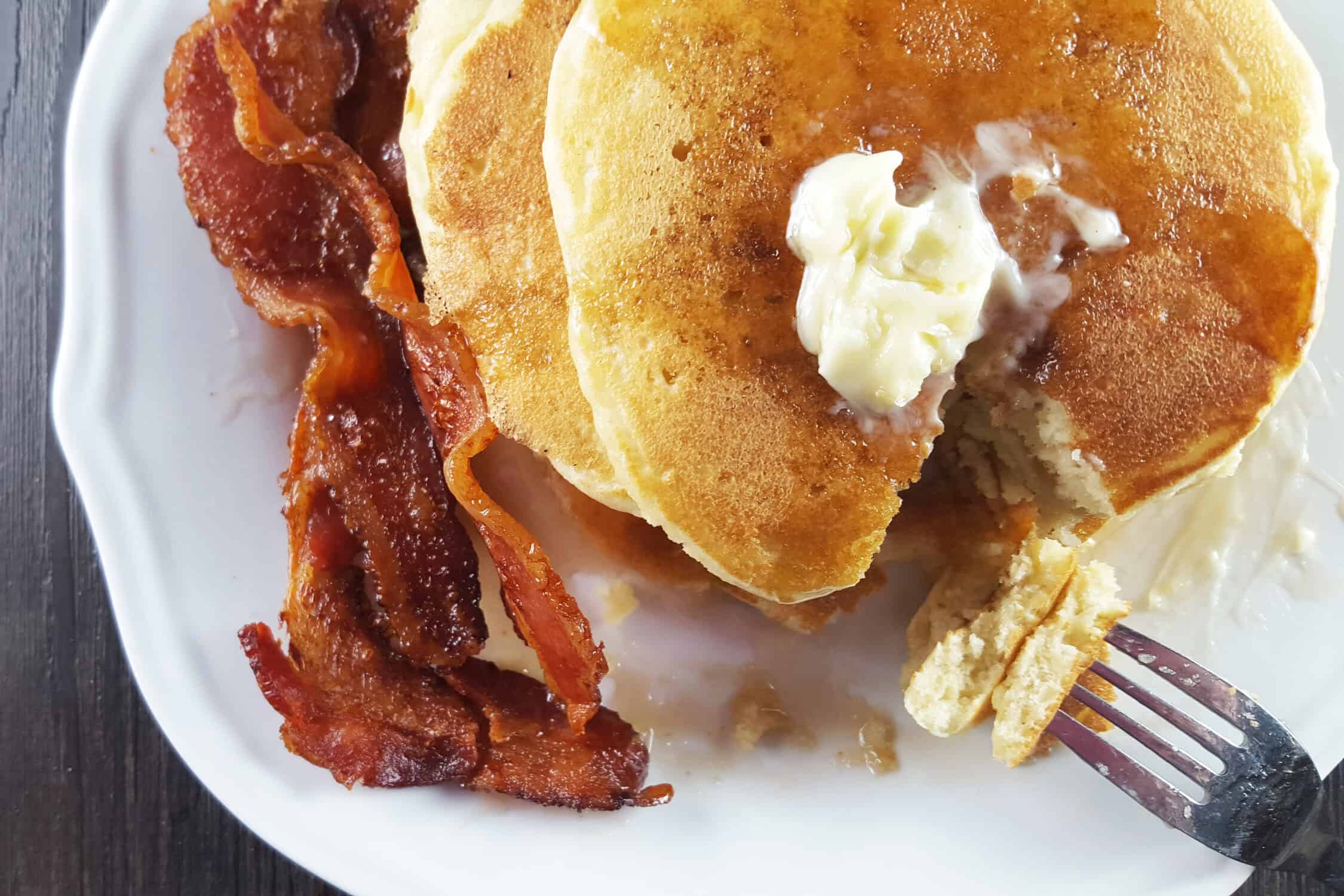 Fluffy Buttermilk Pancakes with Bacon on a white plate 