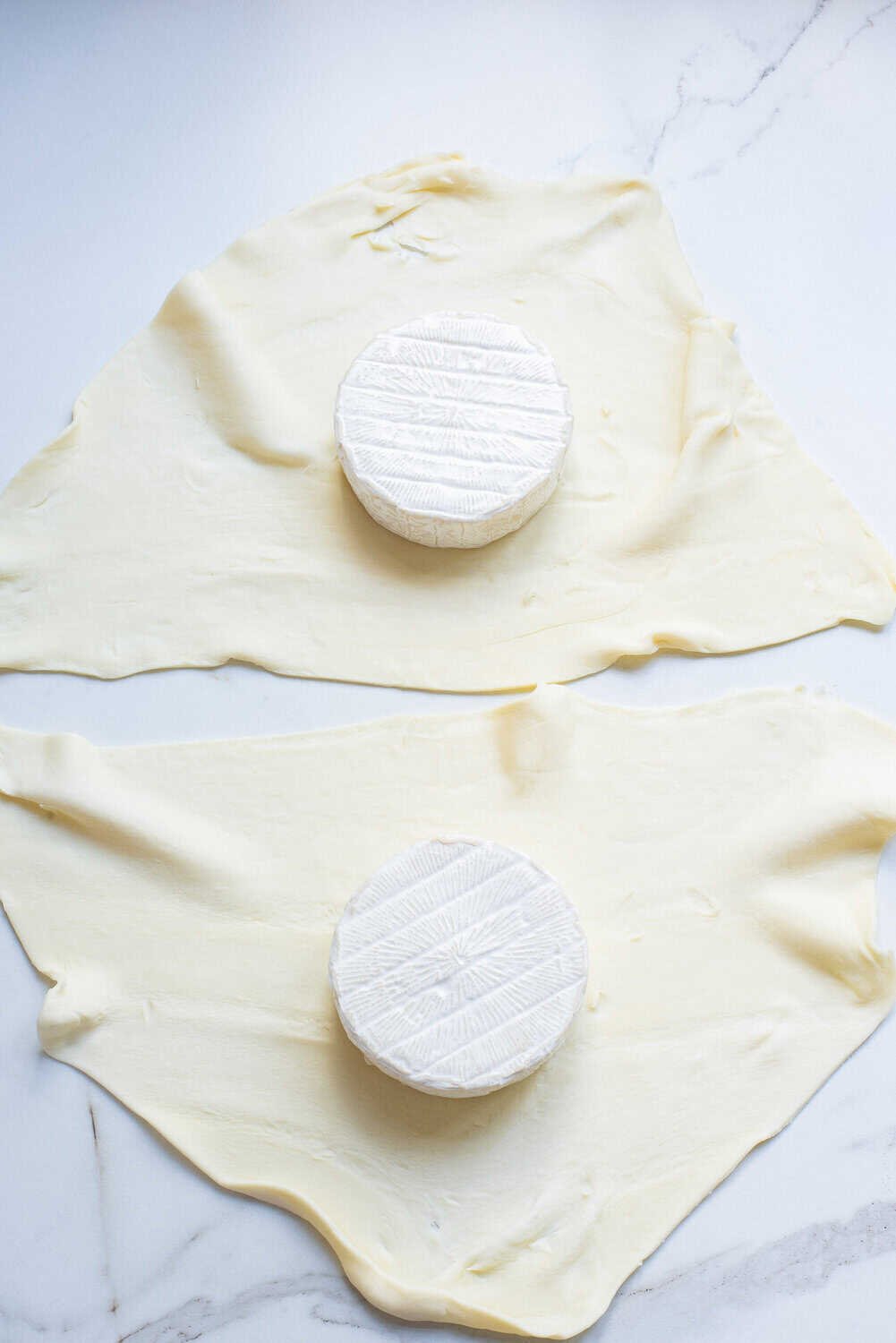 puff pastry cut in half with wheels of brie on them