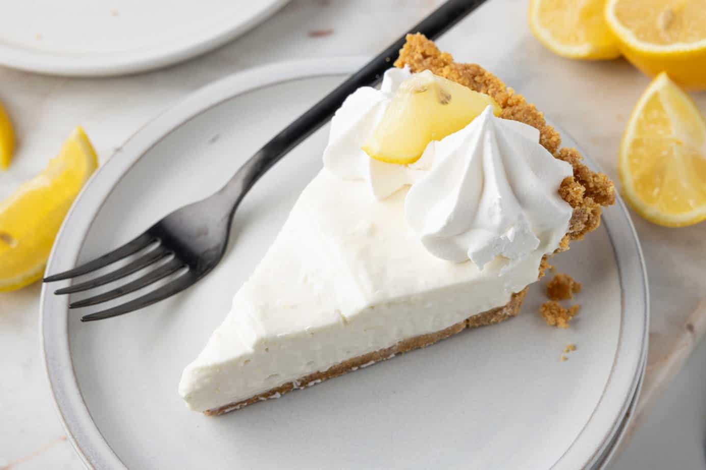 a slice of Lemon Icebox Pie on a stack of white plates