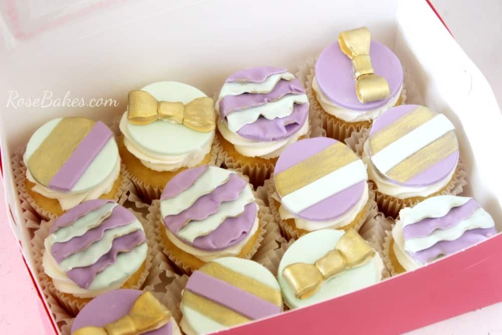 Mint, Gold, and Purple Cupcake Toppers. Some have gold bows and some are ruffled.