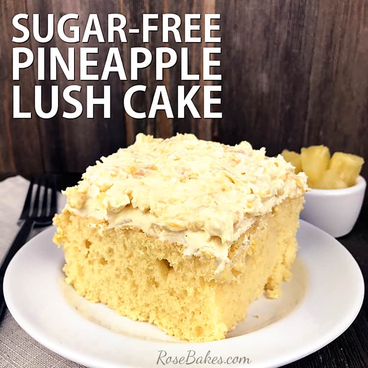 A square of Pineapple Lush Cake on a white plate with a bowl of fresh pineapple in the background.