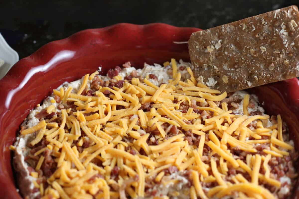 million dollar dip with a cracker in the dish