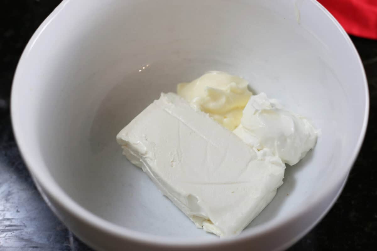 cream cheese, mayo and sour cream in a white mixing bowl