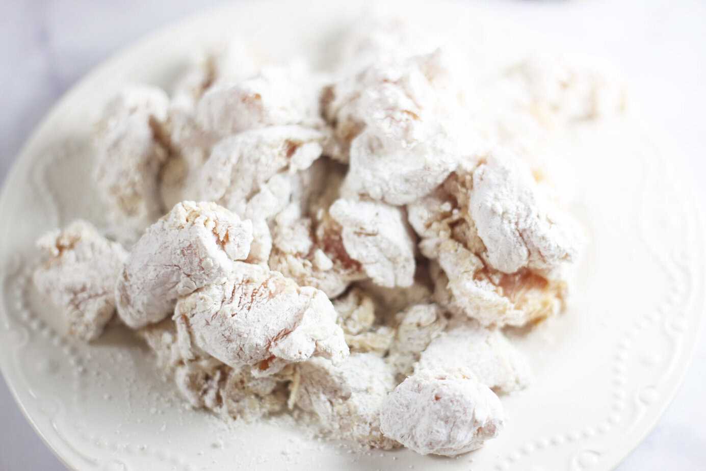 flour coated chicken chunks on a white plate