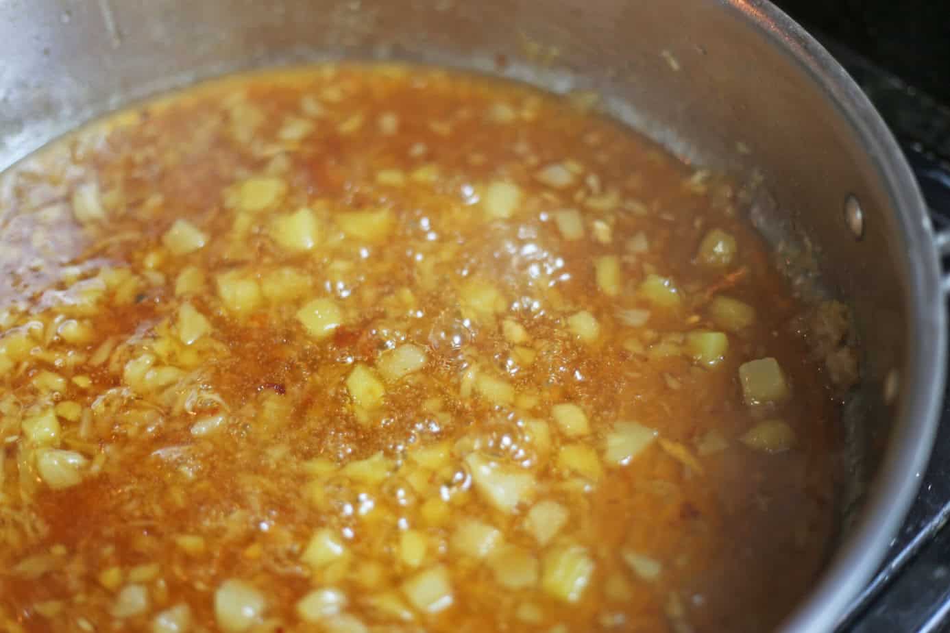 boiling pineapple orange sauce in a skillet