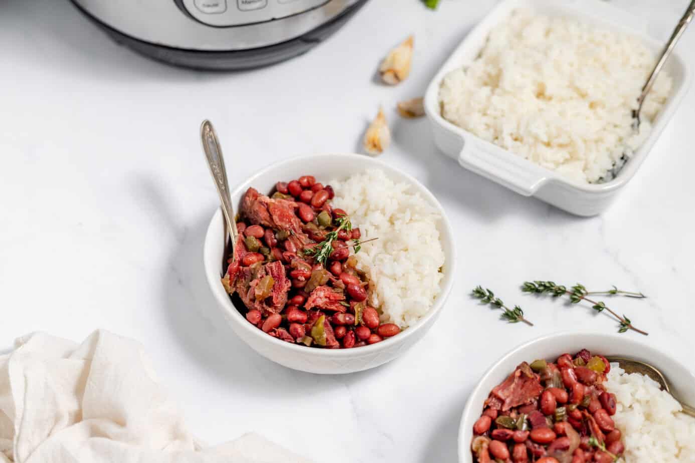 white bowl half filled with red beans and half filled with white rice on a cutting board