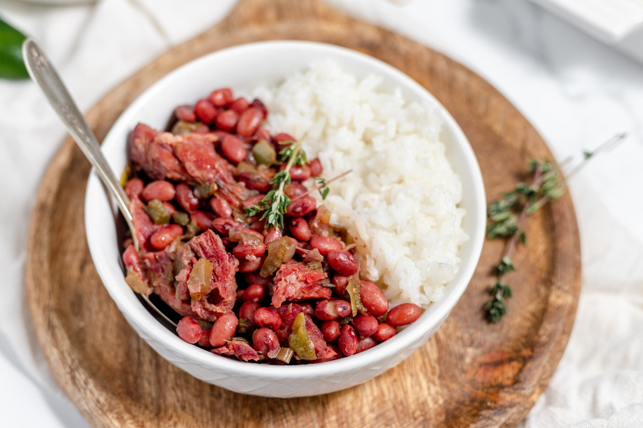 instant pot red beans and rice in a white bowl on a wooden cutting board