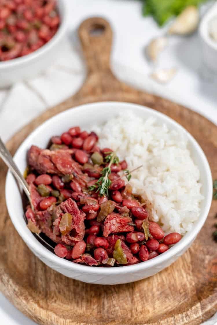 instant pot red beans and rice in a white bowl on a wooden cutting board