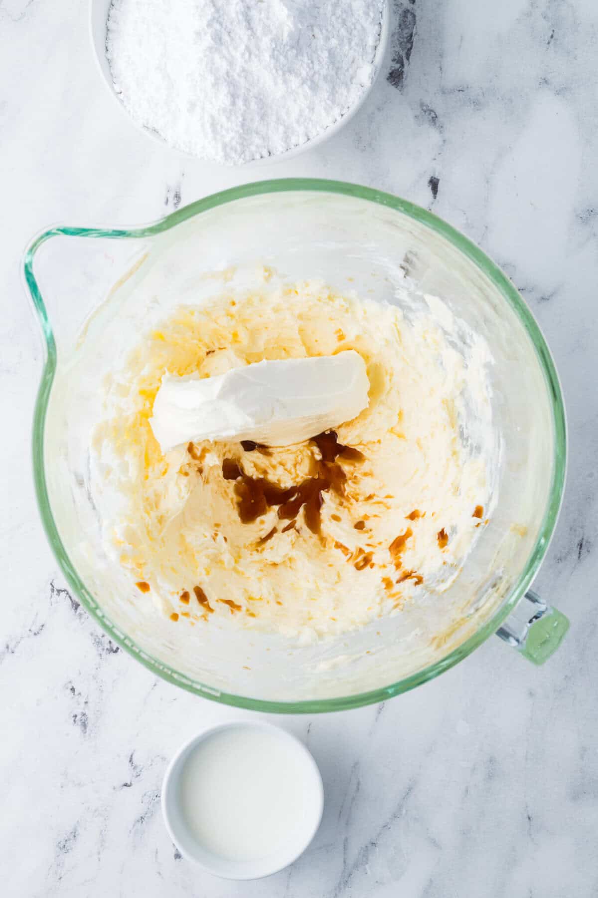 cream cheese and vanilla added to mixing bowl with creamed butter and shortening