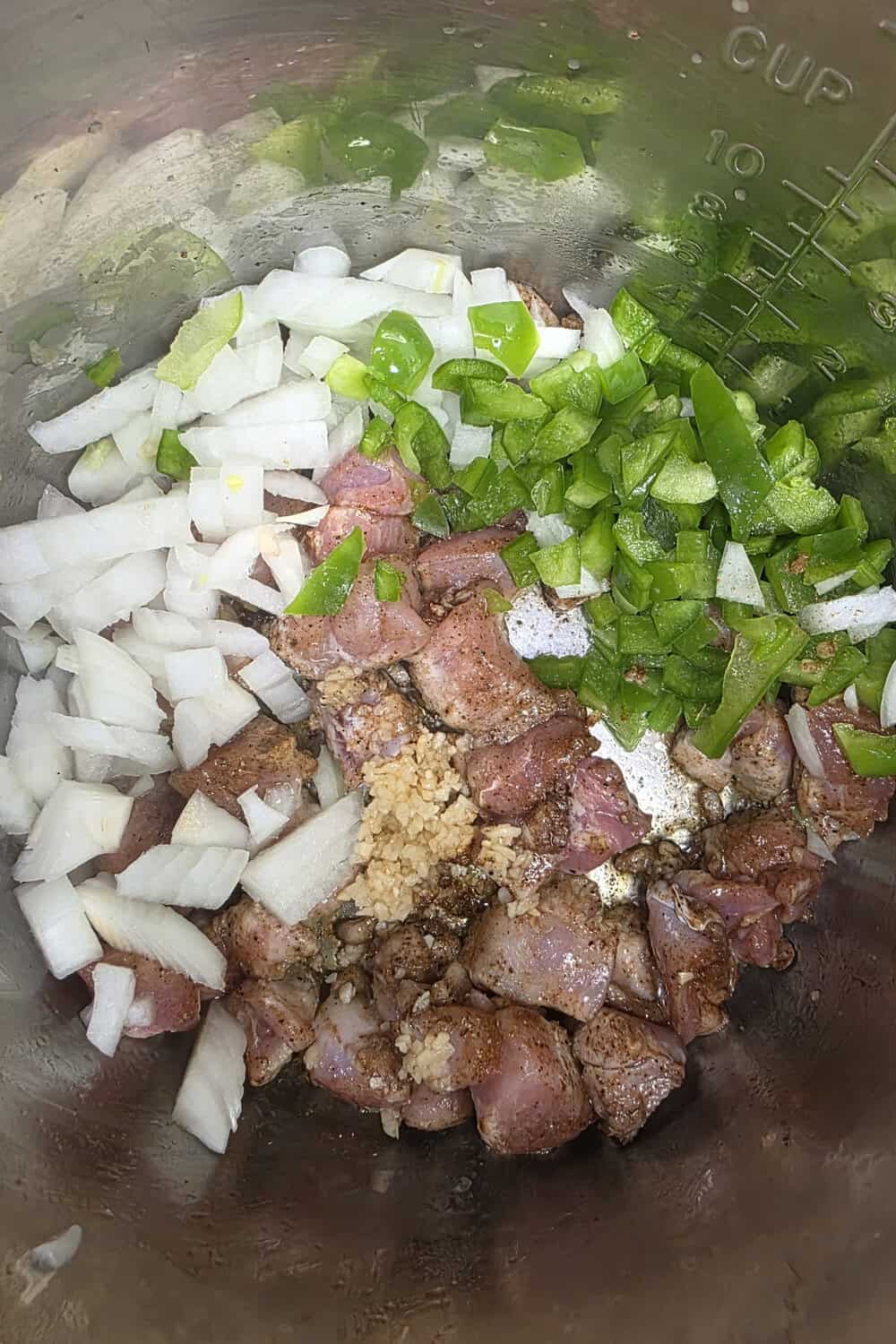 onions, peppers, garlic and some seasonings added to chicken in instant pot