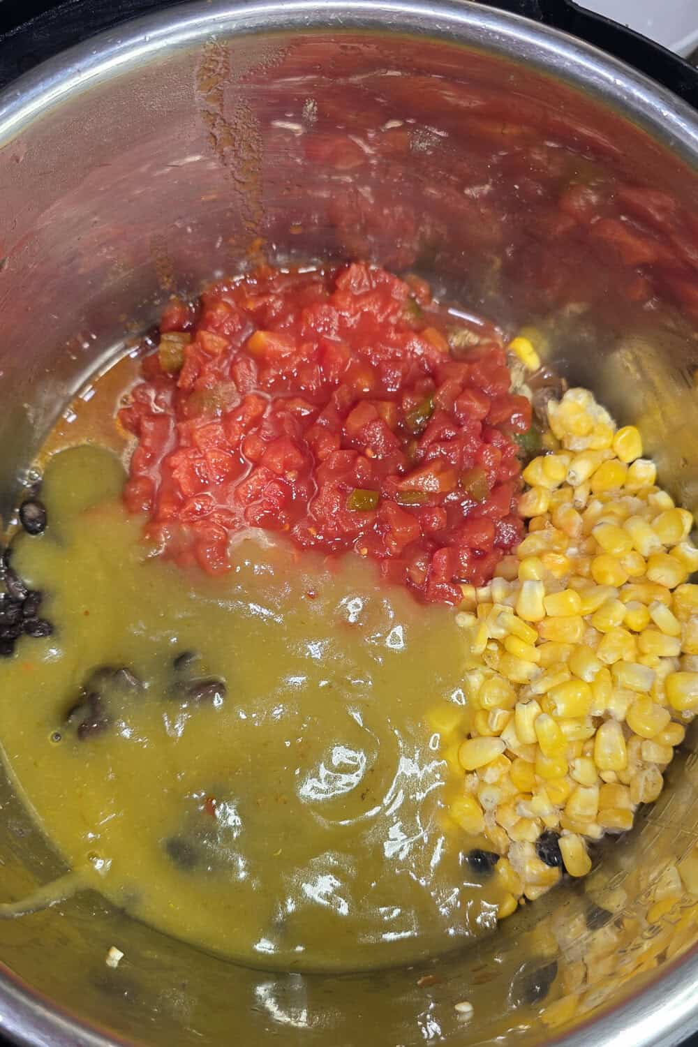 frozen corn, diced tomatoes with green chiles added to cooked chicken in instant pot