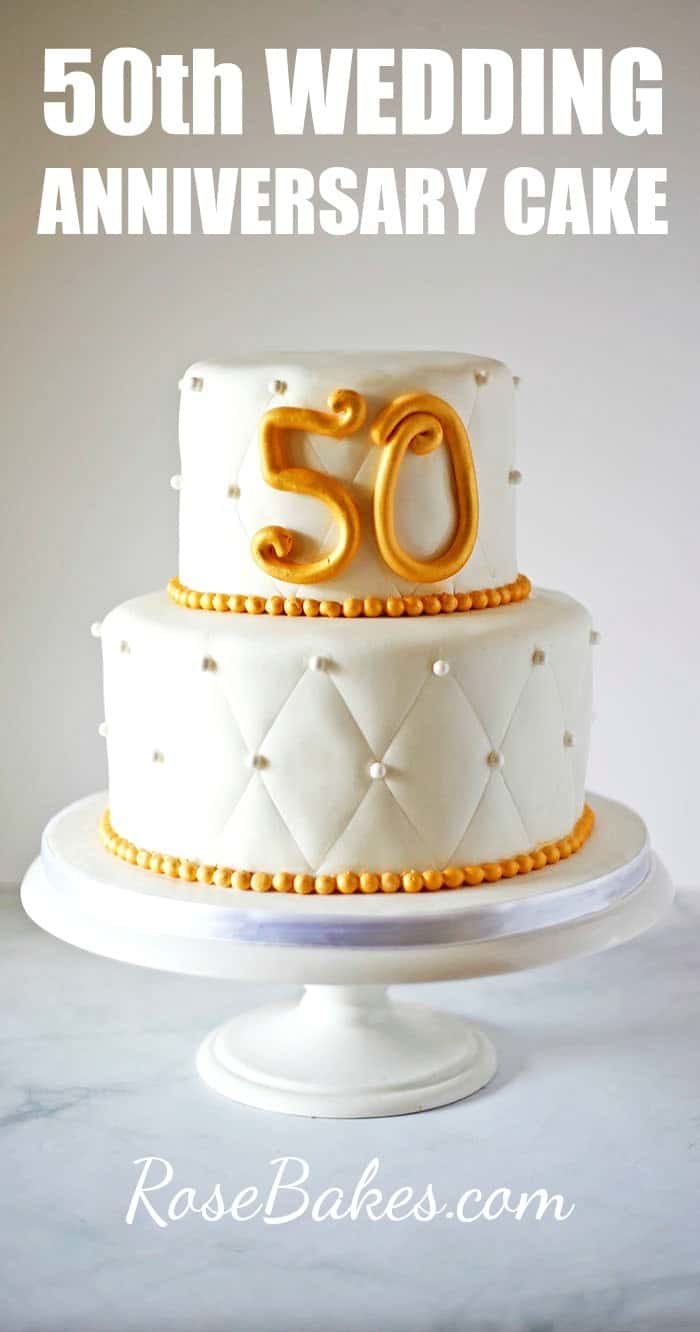 Two tiered cake with fondant numbers 50
 with text overlay saying 50th wedding anniversary cake