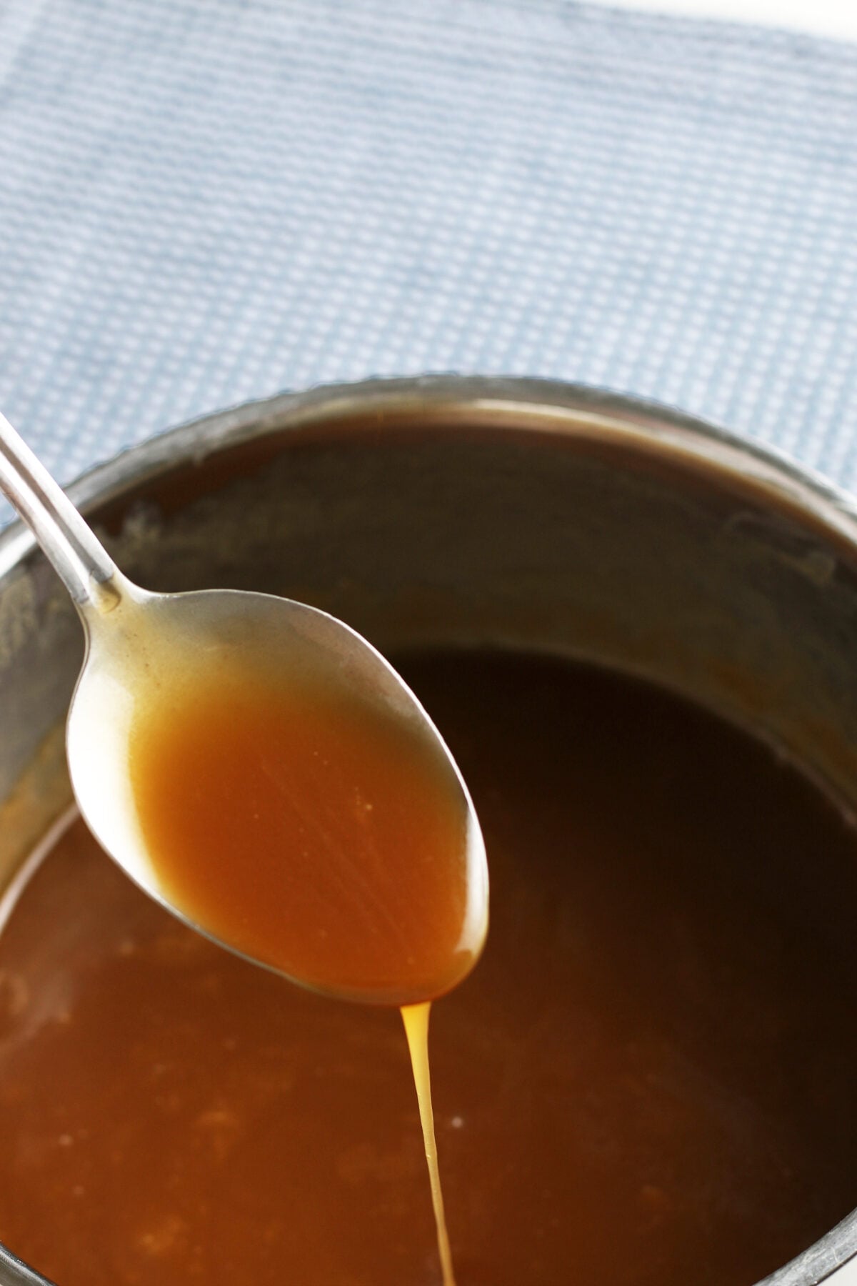 caramel dripping off a spoon into a pot